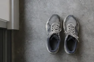 Paire de chaussures de sport usées posées côte à côte sur un sol gris.